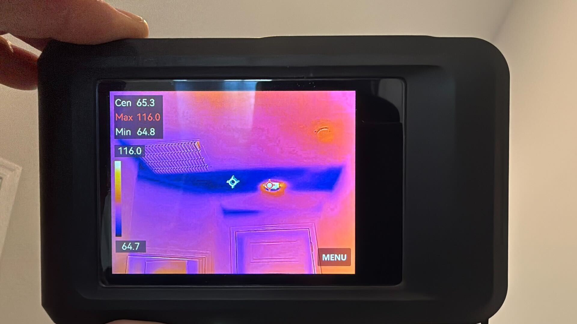 Thermal imaging camera detecting heat loss and temperature variations on an interior ceiling during a home inspection.