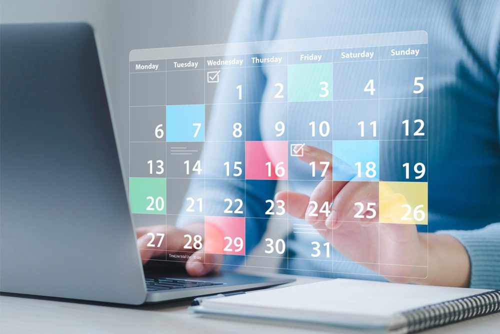 Person using a laptop with a digital calendar interface to schedule tasks and manage work deadlines.
